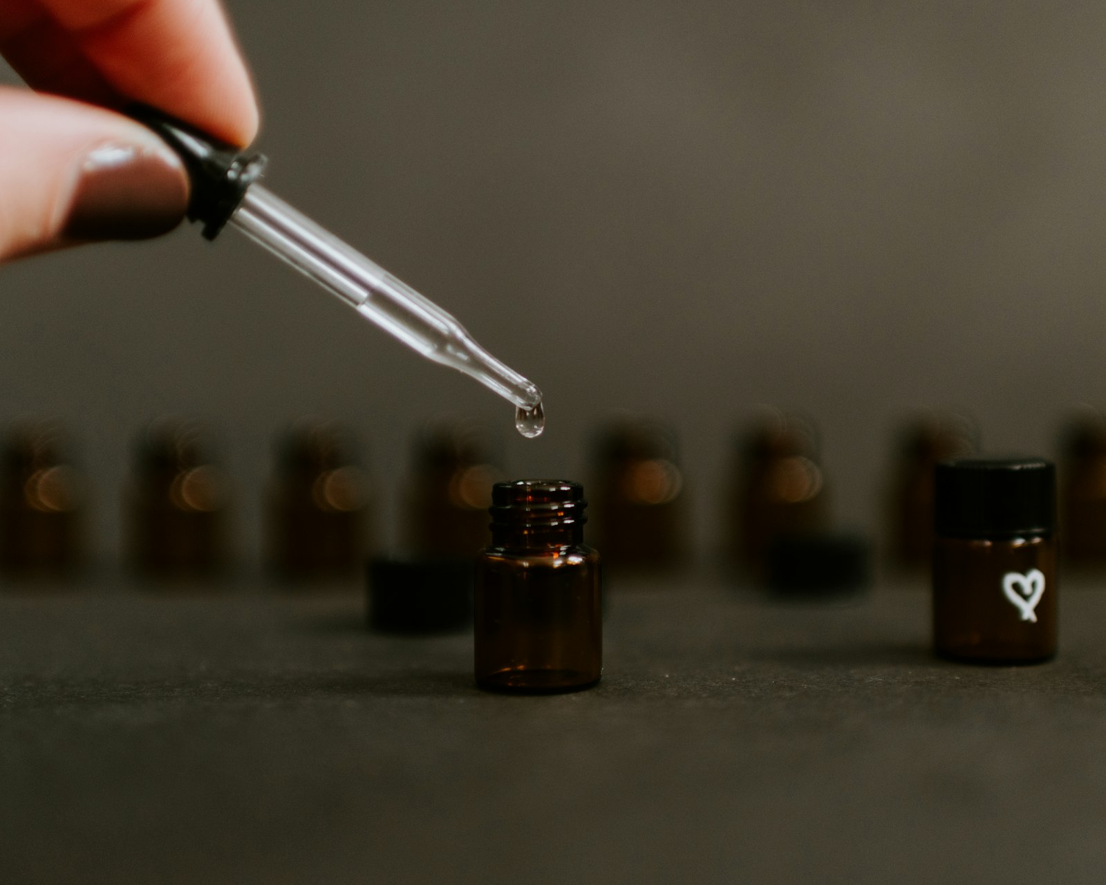 Amber essential-oil bottle with dropper in a calm, spa-like still