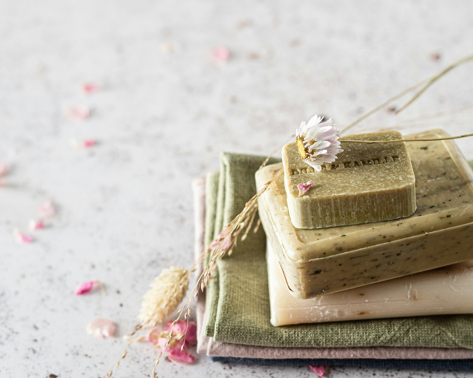 Handmade soap bars styled on a soft floral textile